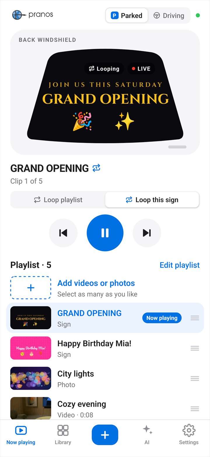 The Pranos app’s Now playing screen: Parked is selected, and the GRAND OPENING sign plays in the back windshield preview, with the play controls below