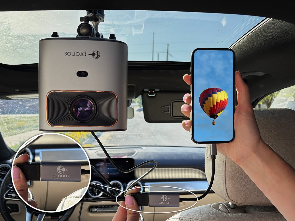 HDMI setup in a car: the HoloGlass unit mounted at the roof, its HDMI cable plugged into the PRANOS USB-C to HDMI adapter on a phone